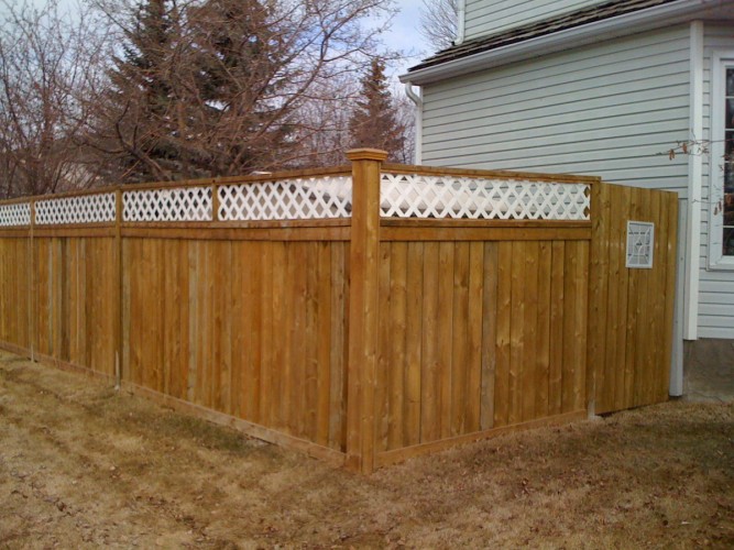 Wooden fence with the check pattern on the top placing just outside of house